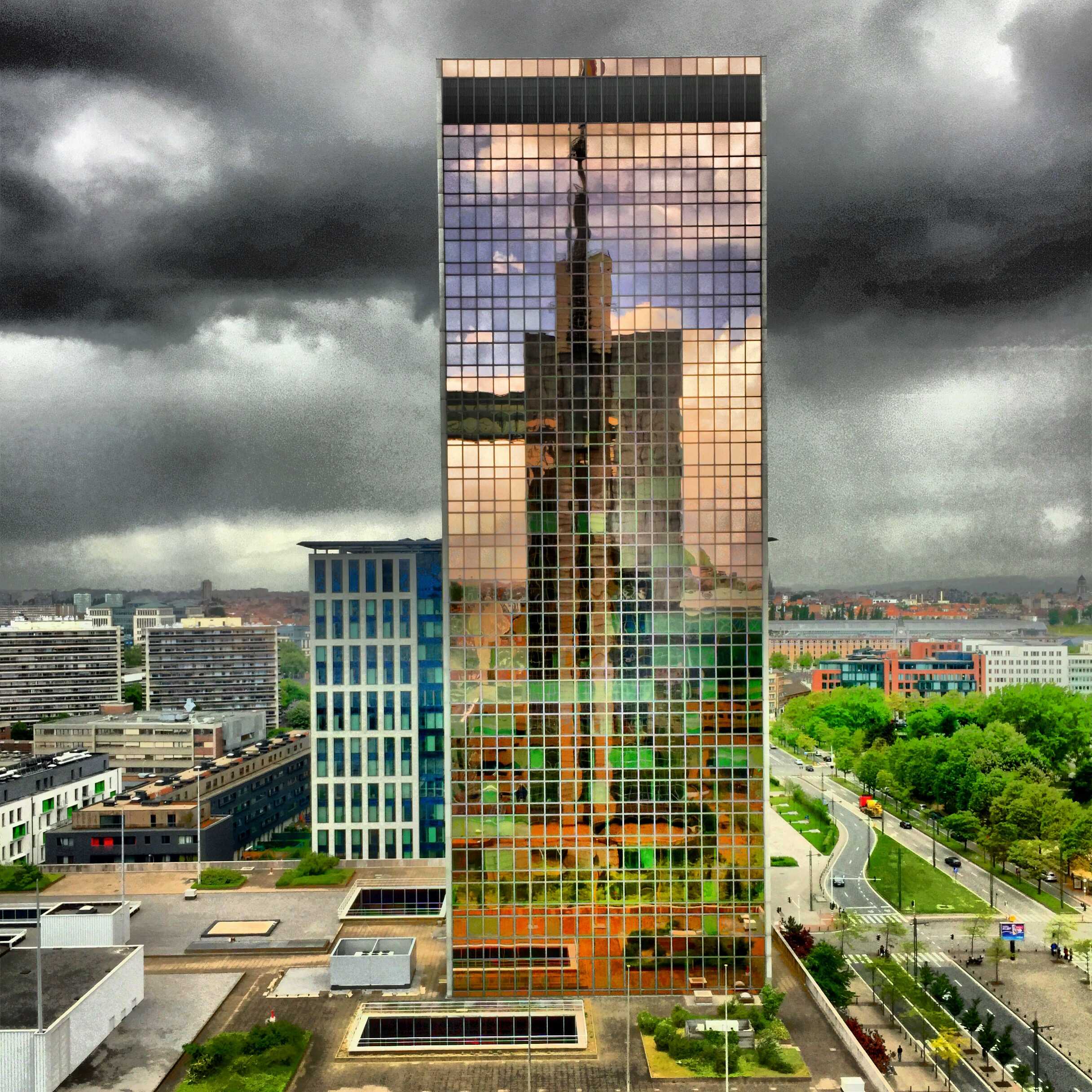 A large skyscraper is reflected in a glass building, showcasing the potential consequences of bandwidth caps on the internet's future.