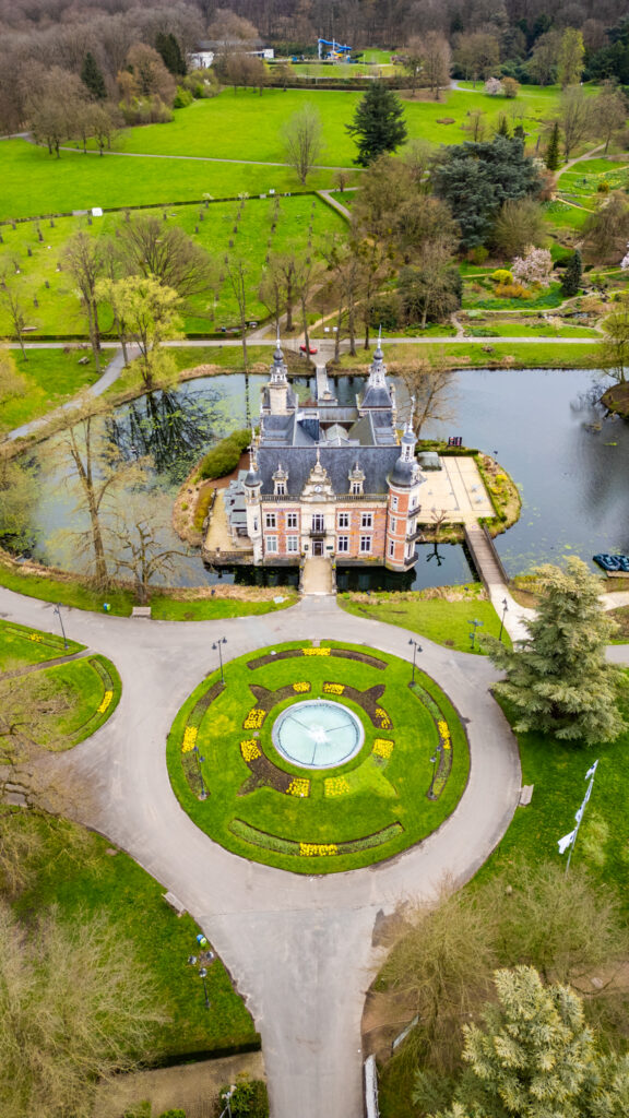 Aerial view of the picturesque Castle of Huizingen with landscaped gardens and a pond.